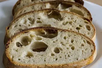 Thick slices of the finished sourdough showing an open, airy crumb
